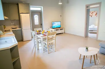 a kitchen and living room with a table and chairs at Aphrodite’s Cozy House in Kolymvari