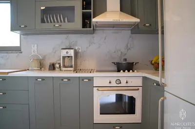 a kitchen with blue cabinets and an oven in it at Aphrodite’s Cozy House in Kolymvari