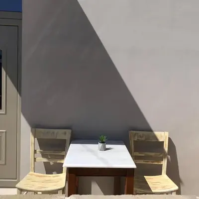 a table and two chairs with a potted plant on it at Aphrodite’s Cozy House in Kolymvari