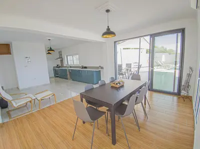 a kitchen and dining room with a table and chairs at Modern villa with infinity pool close to the sea in Tavronitis