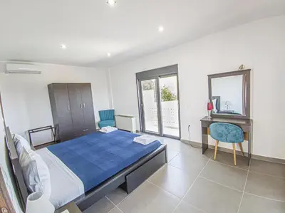 a bedroom with a bed and a desk in it at Modern villa with infinity pool close to the sea in Tavronitis