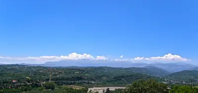a view of the mountains and clouds in the sky at Modern villa with infinity pool close to the sea in Tavronitis