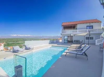 a villa with a swimming pool and a house at Modern villa with infinity pool close to the sea in Tavronitis