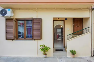 a building with two plants in front of a door at CASA MARIGO (OLD HARBOUR) in Chania Town