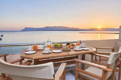 a table with food on a balcony with a view of the ocean at Sea View House in Kissamos