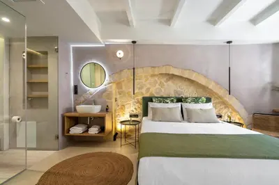 a bedroom with a large bed and a bathroom at Monk Rooms in Chania Town