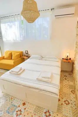 a bedroom with a large bed and a couch at Ravi Boutique Home - 1 minute walk from beach in Kalyves