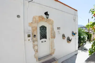 a white building with a white door with a window at Ravi Boutique Home - 1 minute walk from beach in Kalyves