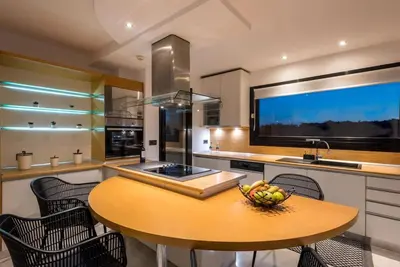 a kitchen with a table with a bowl of fruit on it at Gregorys Private Luxury Villa with Heated Pool & Gardens in SFakianalíon