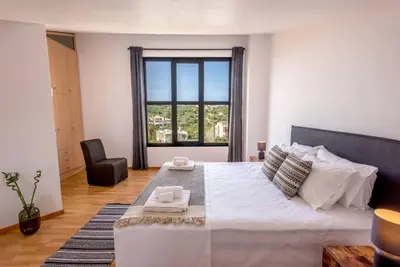 a bedroom with a large bed with a large window at Gregorys Private Luxury Villa with Heated Pool & Gardens in SFakianalíon