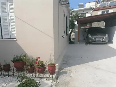 a car parked next to a building with potted plants at Lemon Tree House in Kalyves