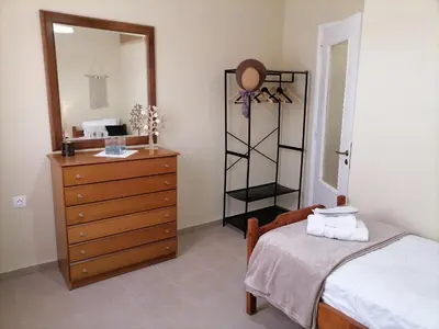 a bedroom with a bed and a dresser and a mirror at Lemon Tree House in Kalyves