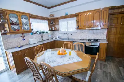a kitchen with a wooden table and a table and chairs at Paradise House with Private Pool in Kissamos
