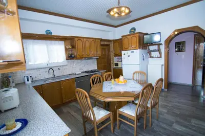 a kitchen with a table and chairs and a kitchen with a refrigerator at Paradise House with Private Pool in Kissamos