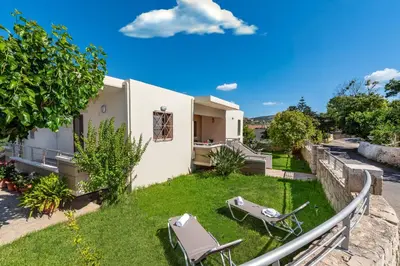a house with a yard with chairs and a table at Villa Alexandra in Kolymvari