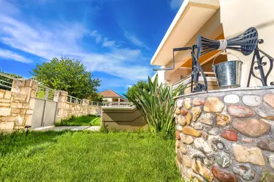 a stone retaining wall in front of a house at Villa Alexandra in Kolymvari