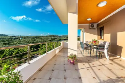 a balcony with a table and chairs and a view at Villa Alexandra in Kolymvari