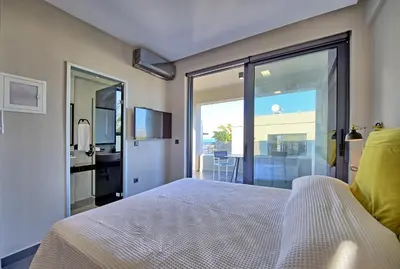 a bedroom with a bed and a sliding glass door at Villa Maripol by PosarelliVillas in Galatás