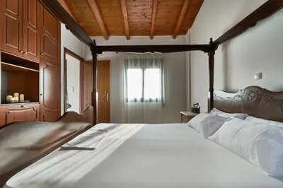 a bedroom with a large bed with a wooden headboard at Villa Politini by PosarelliVillas in Vryses