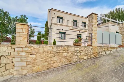 a stone wall in front of a house at Villa Politini by PosarelliVillas in Vryses