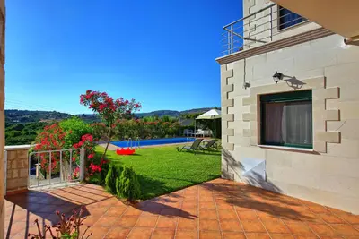 a house with a patio and a yard at Villa Politini by PosarelliVillas in Vryses