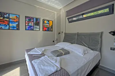 a bedroom with a bed with white sheets and pillows at Villa Popi - modern villa with private pool by PosarelliVillas in Galatás