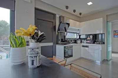 a kitchen with a table with a vase of flowers on it at Villa Popi - modern villa with private pool by PosarelliVillas in Galatás