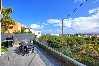 a patio with a table and chairs on a balcony at Villa Popi - modern villa with private pool by PosarelliVillas in Galatás