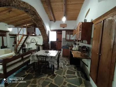 a kitchen with a table in the middle of a room at Afrodite's House-Restaurated Oil Factory in Ayiá