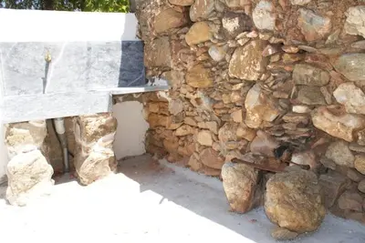 a bench sitting next to a stone wall at Afrodite's House-Restaurated Oil Factory in Ayiá