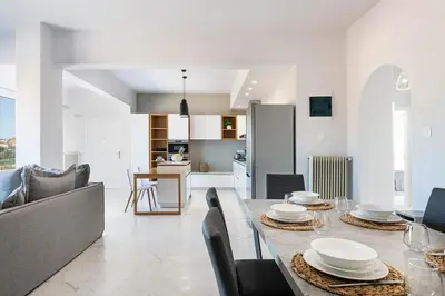 a dining room and living room with a table and chairs at West City Apartment in Chania Town
