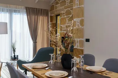 a dining room with a wooden table and blue chairs at Effrosini Panorama View in Nopíyia