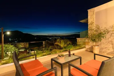 a patio with a table and chairs at night at Effrosini Panorama View in Nopíyia