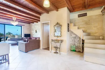 a living room with a couch and a staircase at SpiliaInn in Spiliá