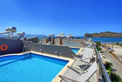 a pool with chairs and the ocean in the background at Cabanavillas Casablanca by PosarelliVillas in Plaka