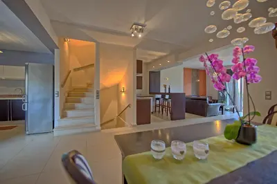 a kitchen and living room with a table with wine glasses at Cabanavillas Casablanca by PosarelliVillas in Plaka