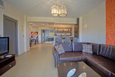 a living room with a brown leather couch and a television at Cabanavillas Casablanca by PosarelliVillas in Plaka