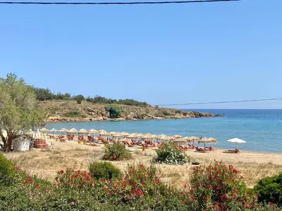 a beach with umbrellas and chairs and the ocean at Golden Key apartments in Chania Town