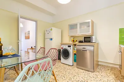 a kitchen with a table and a refrigerator and a microwave at Golden Key apartments in Chania Town