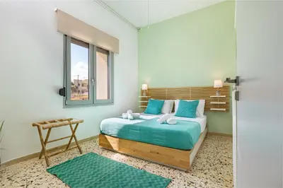 a bedroom with a bed with blue sheets and a window at Golden Key apartments in Chania Town