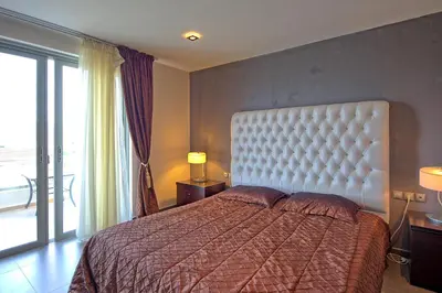 a bedroom with a bed and a large window at Cabanavillas Rio by PosarelliVillas in Agia Marina Nea Kydonias