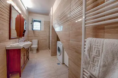 a bathroom with a sink and a washing machine at Villa Despanto by PosarelliVillas in Litsárdha