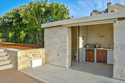 an outdoor kitchen with a stone building at Villa Despanto by PosarelliVillas in Litsárdha