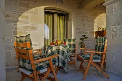a table and chairs sitting on a porch at Villa Despanto by PosarelliVillas in Litsárdha