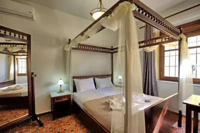 a bedroom with a canopy bed and a mirror at Villa Sevi Grande by PosarelliVillas in Káto Vení