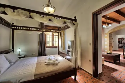 a bedroom with a large bed with a wooden frame at Villa Sevi Grande by PosarelliVillas in Káto Vení