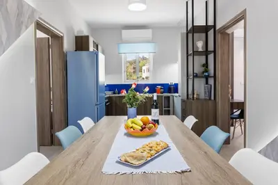 a table with a bowl of fruit and a bowl of bread at Luxury Villa Eva-Mari with jacuzzi, 50m from the beach in Stalos