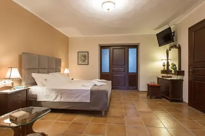 a bedroom with a bed and a table and a television at Villa Antina by PosarelliVillas in Litsárdha