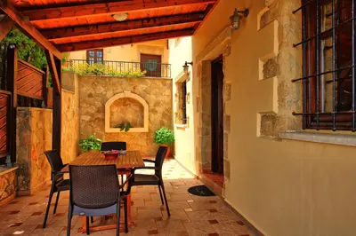 an outdoor patio with a wooden table and chairs at Villa Romantic Sevi by PosarelliVillas in Káto Vení