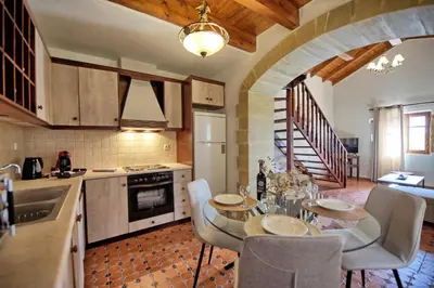 a kitchen with a table and chairs in a kitchen at Villa Romantic Sevi by PosarelliVillas in Káto Vení